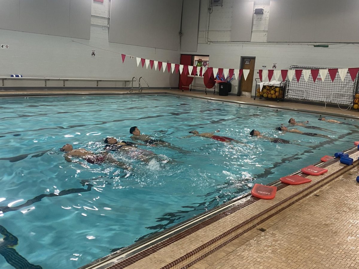 Members of the boy’s swim team use different swimming techniques and to warm up on Nov. 19.