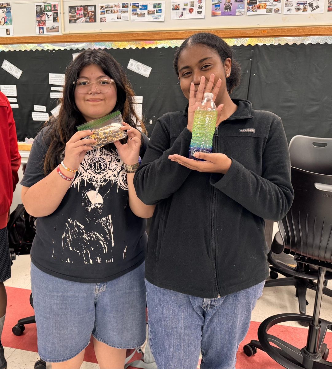 Juniors Dulce Carmargo and Kaitlyn Carey display the bird feeder and lava lamp that they made at the Science and Ecology Club's May 6 meeting.
