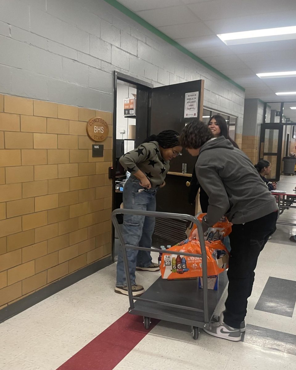 Devoted DECA members Donielle Sylva and Angel Pompa prepare concessions to sell for the Boys Basketball game on Dec. 9 at Bremen. DECA students get real-world business experience running the school store and managing concessions for events at Bremen.