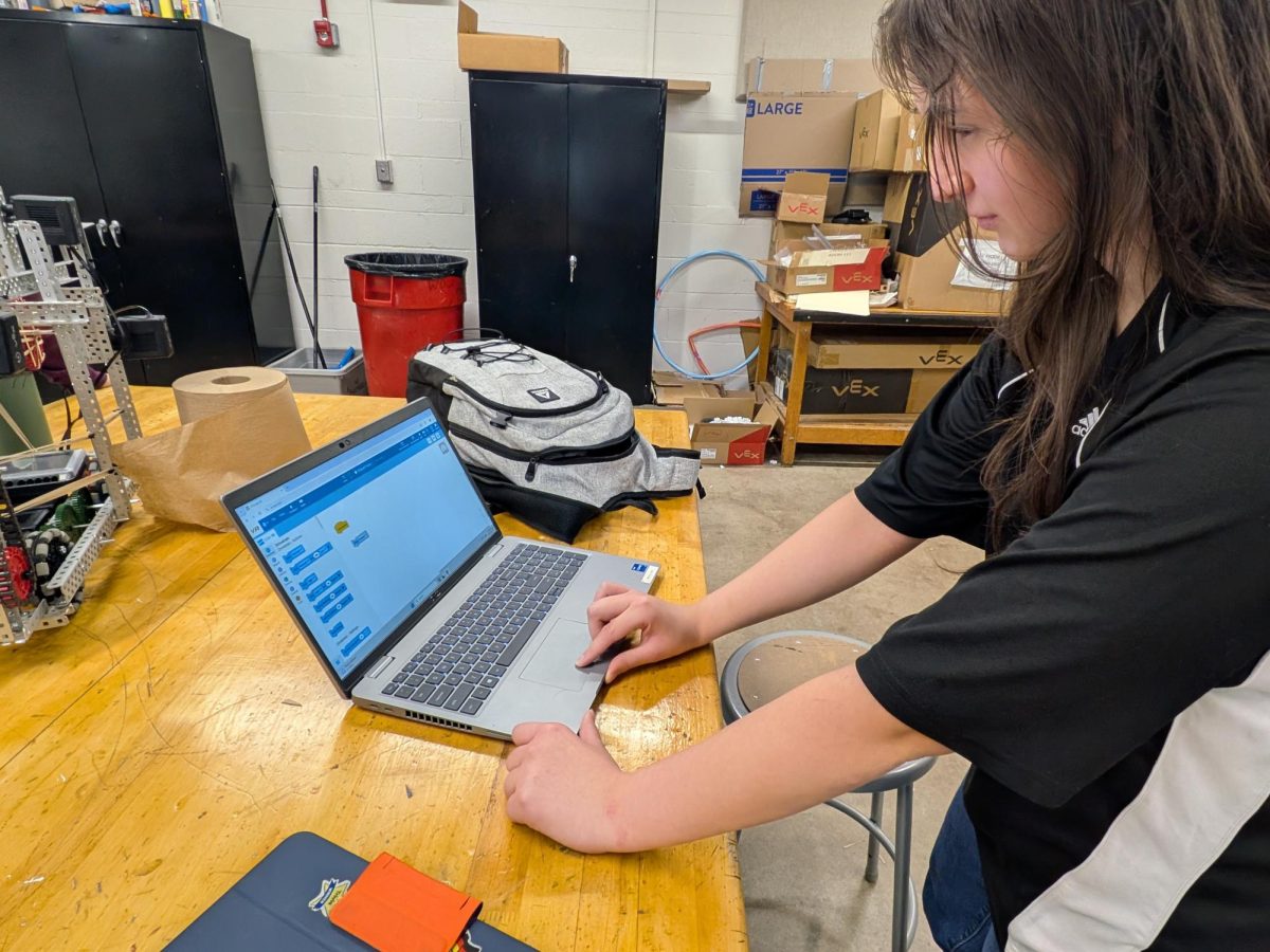 At the April 14 meeting, freshman Daniela Cazares diligently works on programming the Robotics Team's robot for competition using Scratch: a block-based coding language. The club is in the final stages of preparation for their competition on Saturday, April 18. The winning team will have a robot that efficiently drops the most balls into the goal.