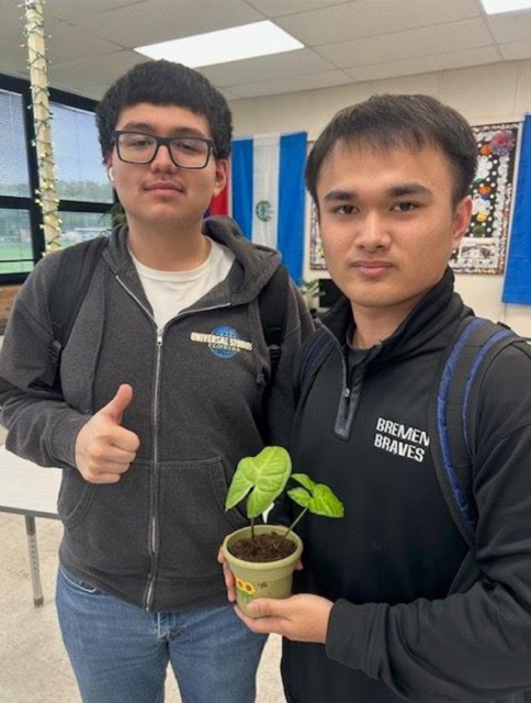 Senior Interact members Osvaldo Carranza-Barrios and Phuong Le show off their newly planted sprout from the final meeting as Bremen students. 